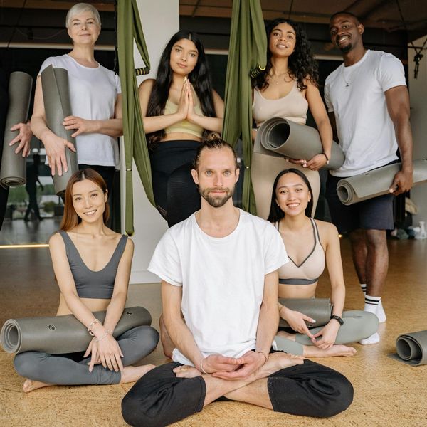 Diverse group of people sitting together in a calm yoga studio.