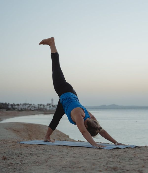 Woman in a peaceful yoga pose against a dark, smoky background.